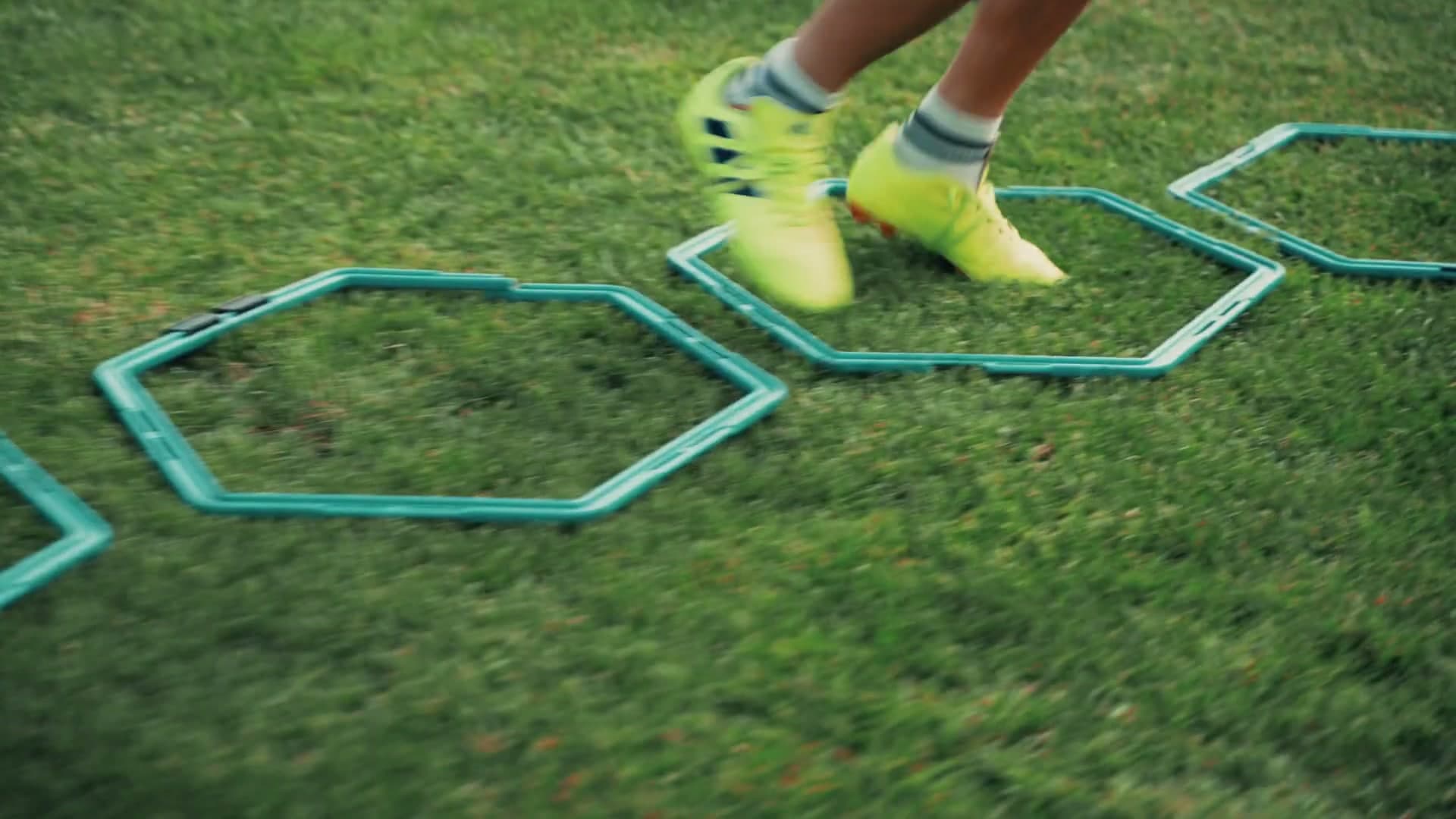 Detail práce nôh mladého hráča počas technického futbalového cvičenia.